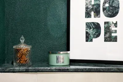 a candle and a container on a counter next to a wall at The Captain Suite in Athens
