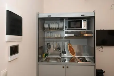 a kitchen with a sink and a microwave at Elida Inn Near ATH Airport in Markopoulo