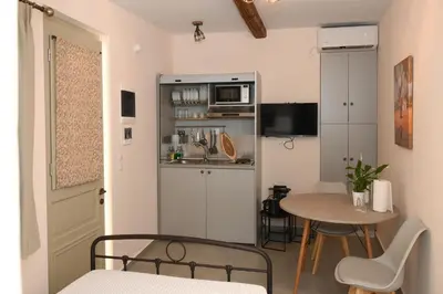 a small room with a table and a kitchen at Elida Inn Near ATH Airport in Markopoulo