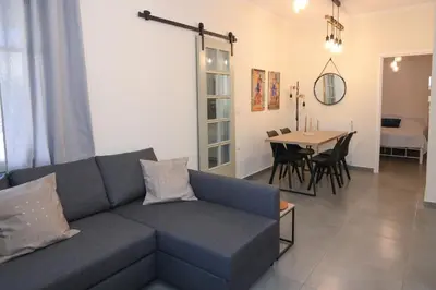 a living room with a blue couch and a table at Elida Inn Near ATH Airport in Markopoulo