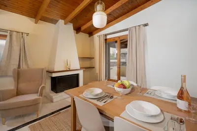 a dining room with a table and a fireplace at Elida Inn Near ATH Airport in Markopoulo