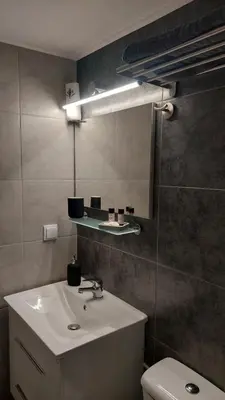 a bathroom with a sink and a mirror and a toilet at Miranda's Apartment Koukaki in Athens