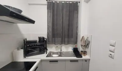a small kitchen with a sink and a window at Miranda's Apartment Koukaki in Athens