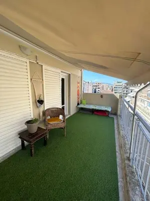 a balcony with green flooring on a building at Bohemian Cozy Flat, with terrace 24h available, self- check in in Athens