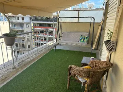 a balcony with a green flooring on a building at Bohemian Cozy Flat, with terrace 24h available, self- check in in Athens