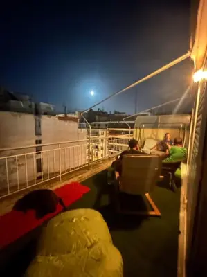 a group of people sitting on a boat at night at Bohemian Cozy Flat, with terrace 24h available, self- check in in Athens