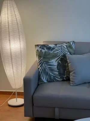 a blue couch with a pillow and a lamp at Acropolis Sidewalk view in Athens