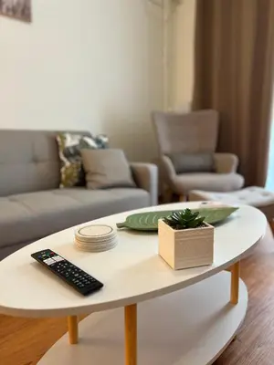 a coffee table in a living room with a remote control at Acropolis Sidewalk view in Athens