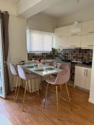 a kitchen with a table and chairs in a room at Acropolis Sidewalk view in Athens