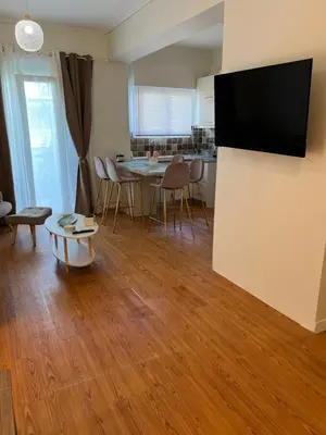 a living room with a table and a television on a wall at Acropolis Sidewalk view in Athens