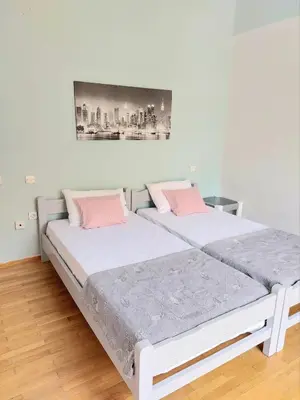 two beds in a white room with pink pillows at Φωτεινό δίκλινο δωμάτιο με θέα! in Athens