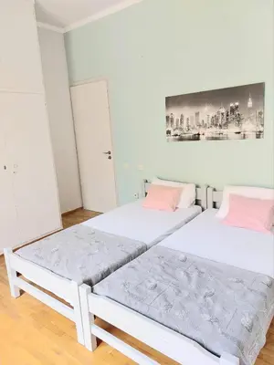 two beds in a room with white walls and pink pillows at Φωτεινό δίκλινο δωμάτιο με θέα! in Athens