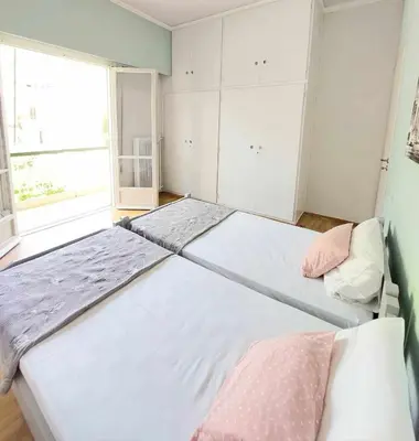two beds in a room with a large window at Φωτεινό δίκλινο δωμάτιο με θέα! in Athens