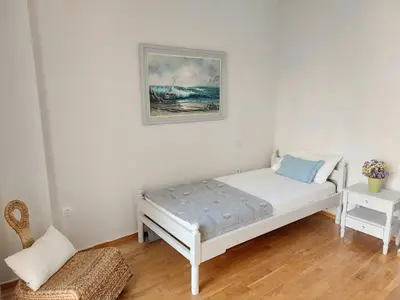 a bedroom with a bed and a picture on the wall at Ήσυχο φωτεινό δωμάτιο με βεράντα in Athens