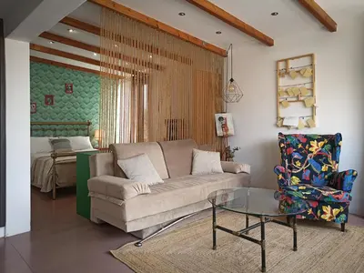 a living room with a couch and a table and a bed at Terrace holiday studio apartment in Athens