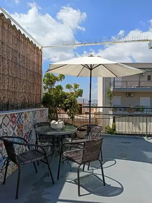 a patio with a table and chairs and an umbrella at Terrace holiday studio apartment in Athens