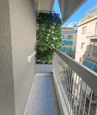 a balcony with a plant on a building at Stylish City Studio 8' From 3 Metro Lines 4th Floor in Athens