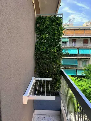 a balcony with a plant on the side of a building at Stylish City Studio 8' From 3 Metro Lines 4th Floor in Athens