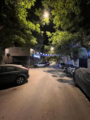 a street at night with cars parked on the road at Stylish City Studio 8' From 3 Metro Lines 4th Floor in Athens