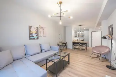 a living room with a couch and a dining room at Superior & Spacious Apartment in Athens