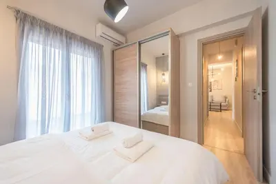 a bedroom with a large white bed with two white towels at Superior & Spacious Apartment in Athens