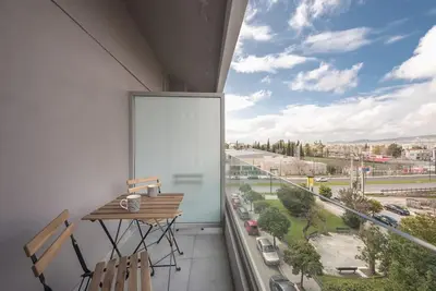 a balcony with a table and chairs and a large window at Superior & Spacious Apartment in Athens
