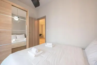 a bedroom with a white bed with two towels on it at Superior & Spacious Apartment in Athens