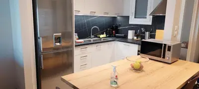 a kitchen with a wooden table with a microwave at Best Acropolis museum apartment in Athens