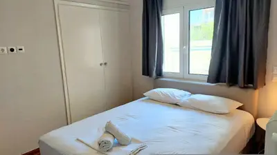 a bedroom with a bed with two pillows and a window at Best Acropolis museum apartment in Athens