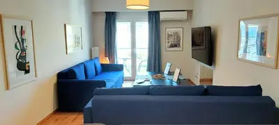 a living room with a blue couch and a table at Best Acropolis museum apartment in Athens