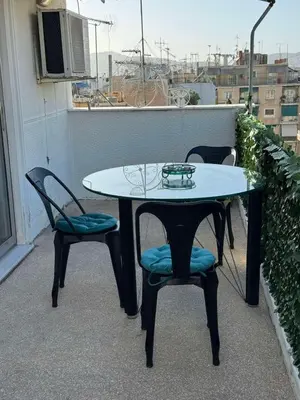 a table and two chairs on a balcony at Studio pellinis in Athens