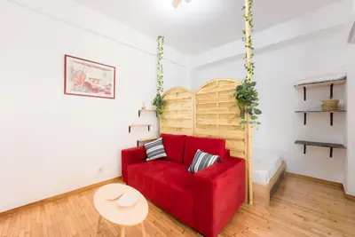 a living room with a red couch and a table at Athens Center Boho Apartment in Athens