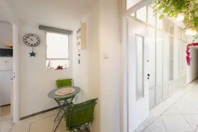 a hallway with a table and a clock on the wall at Athens Center Boho Apartment in Athens