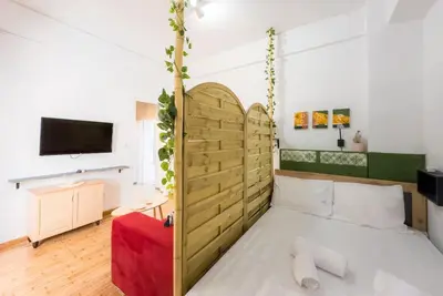 a bedroom with a bed with a wooden headboard at Athens Center Boho Apartment in Athens