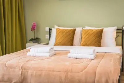 a bedroom with a large bed with towels on it at Top Ten Apartment 3 in Athens