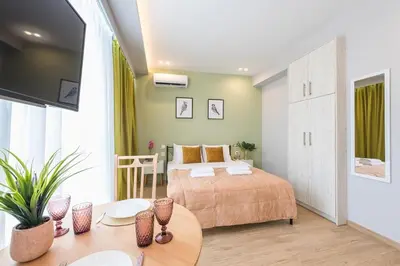 a bedroom with a bed and a table in a room at Top Ten Apartment 3 in Athens
