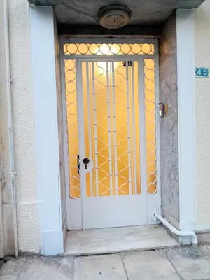 a white door with a gold gate in a building at Underground treasure in Athens