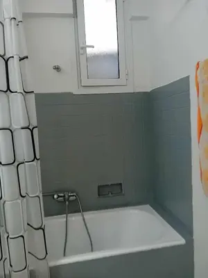 a bath tub in a bathroom with a window at Underground treasure in Athens