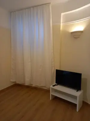 a living room with a flat screen tv in front of a window at Underground treasure in Athens