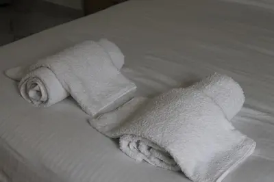 two rolls of white towels sitting on a bed at Syntagma Luxury Suite by CK-1 in Athens