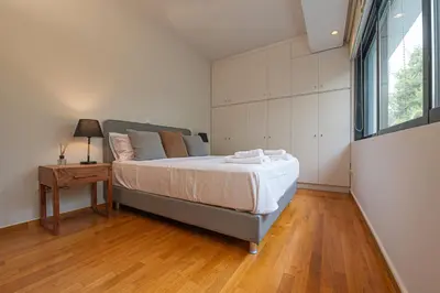 a bedroom with a bed and a table and a window at Stylish Escape in Glyfada in Athens