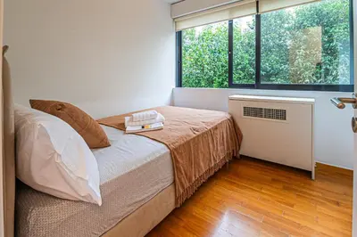 a bedroom with a bed and a large window at Stylish Escape in Glyfada in Athens