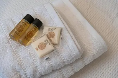three bottles of soap sitting on top of a bed at Stylish Escape in Glyfada in Athens