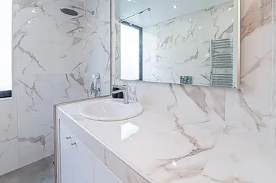 a white bathroom with a sink and a mirror at Stylish Escape in Glyfada in Athens