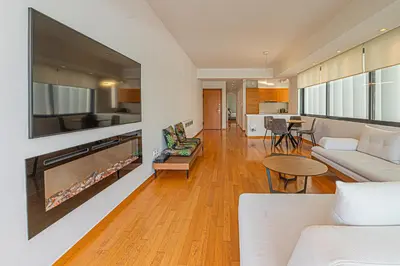 a living room with a large tv and a couch at Stylish Escape in Glyfada in Athens