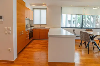 a kitchen with a counter and a table and chairs at Stylish Escape in Glyfada in Athens