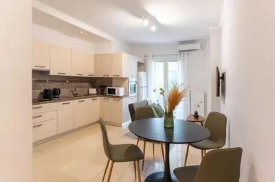 a kitchen and dining room with a table and chairs at Phaedrus Living Alimos Edem Beach Flat in Athens