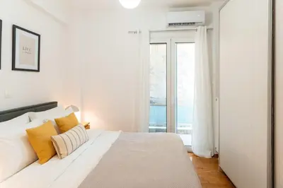 a white bedroom with a large bed with yellow pillows at Phaedrus Living Alimos Edem Beach Flat in Athens