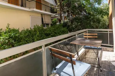 a table and two chairs on a balcony with a building at Phaedrus Living Alimos Edem Beach Flat in Athens