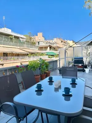 a blue table on a balcony with cups on it at Cozy 3BRs Family Haven near Metro&Acropolis in Athens